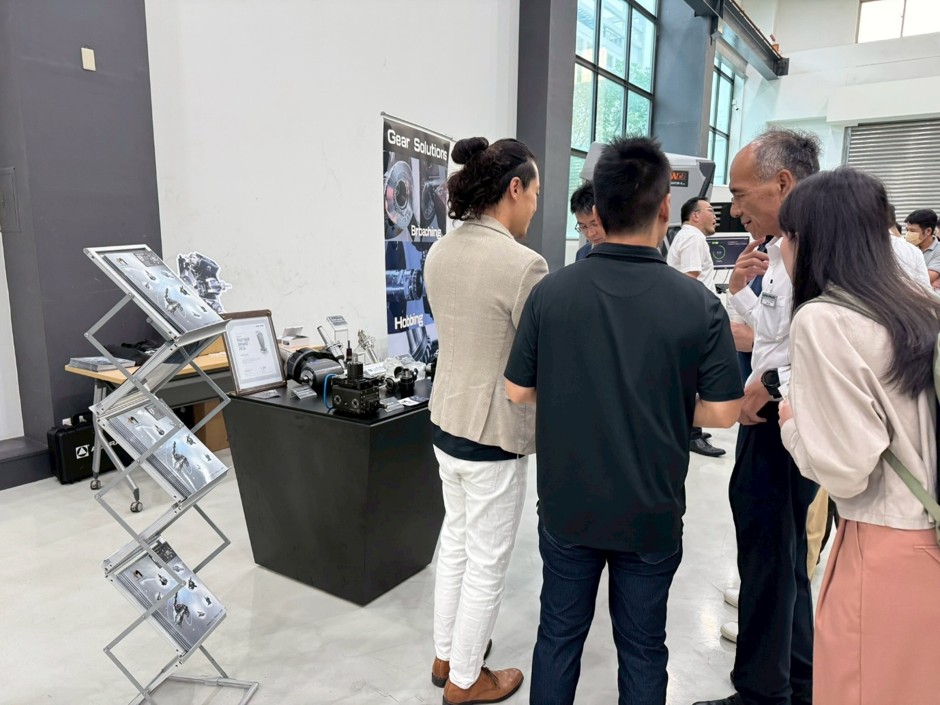 Mongtec team discussing live tooling and gear machining solutions with DMG MORI at seminar booth